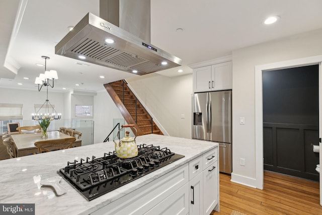 kitchen featuring black gas stovetop, white cabinets, ventilation hood, stainless steel fridge with ice dispenser, and an inviting chandelier