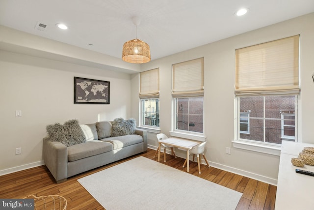 living area with recessed lighting, baseboards, and hardwood / wood-style flooring