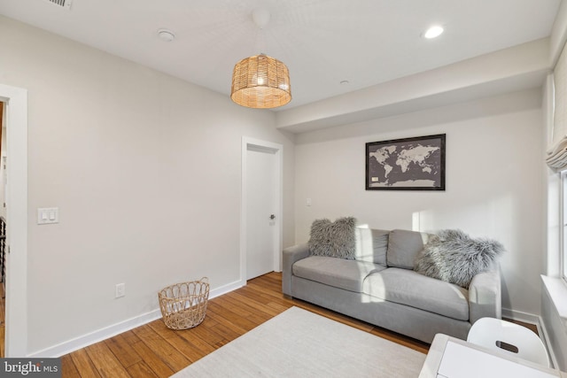 living room featuring baseboards, hardwood / wood-style floors, and recessed lighting