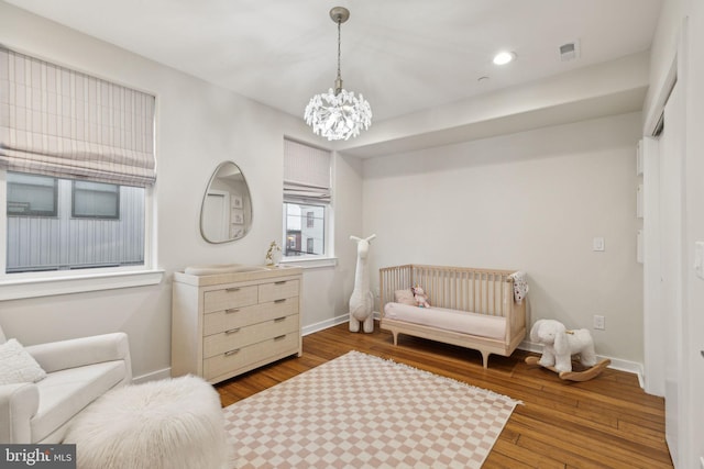 bedroom featuring hardwood / wood-style floors, an inviting chandelier, recessed lighting, and baseboards