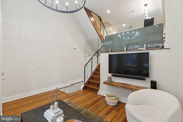 living area with visible vents, stairs, baseboards, and hardwood / wood-style floors