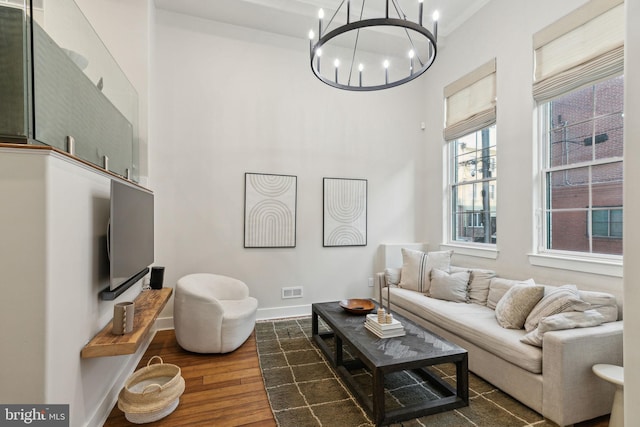 living room with an inviting chandelier, baseboards, and dark wood finished floors