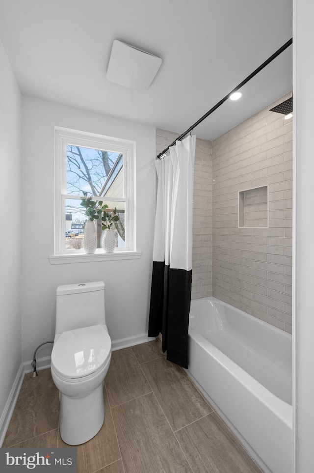 bathroom featuring toilet and shower / bath combo with shower curtain