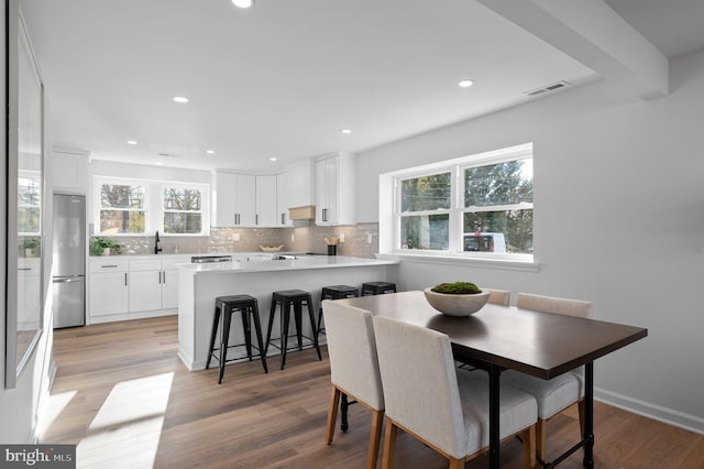 dining space with sink and light hardwood / wood-style flooring