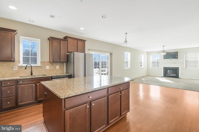 kitchen featuring a kitchen island, pendant lighting, sink, hardwood / wood-style flooring, and stainless steel appliances