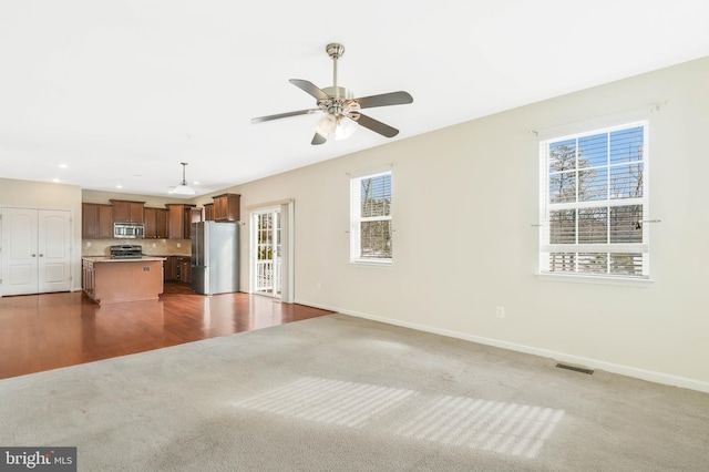 unfurnished living room with carpet flooring and ceiling fan