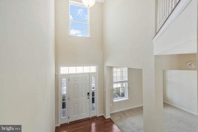 entryway featuring a towering ceiling and carpet floors