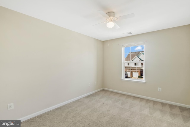 spare room featuring light colored carpet and ceiling fan