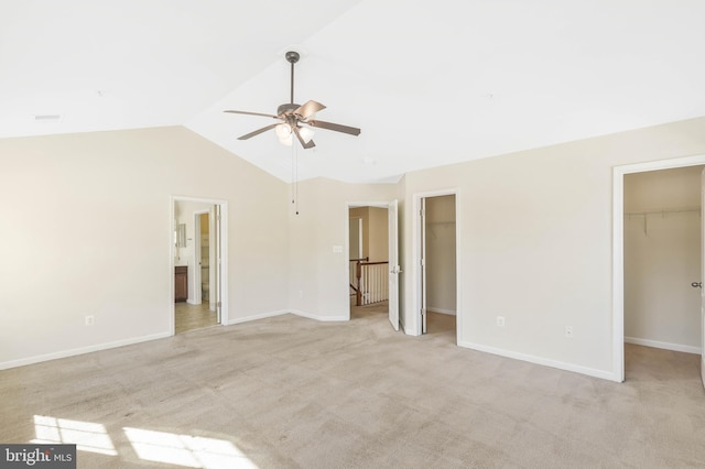 interior space with ceiling fan, connected bathroom, light carpet, a spacious closet, and a closet