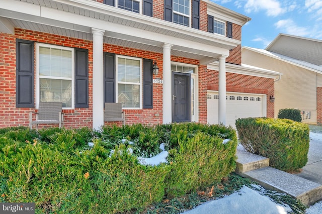 entrance to property featuring a garage and covered porch