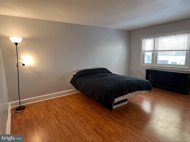 bedroom featuring wood-type flooring and radiator