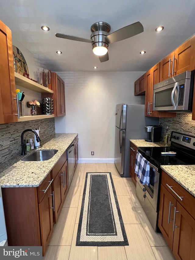 kitchen with light stone countertops, sink, backsplash, and stainless steel appliances