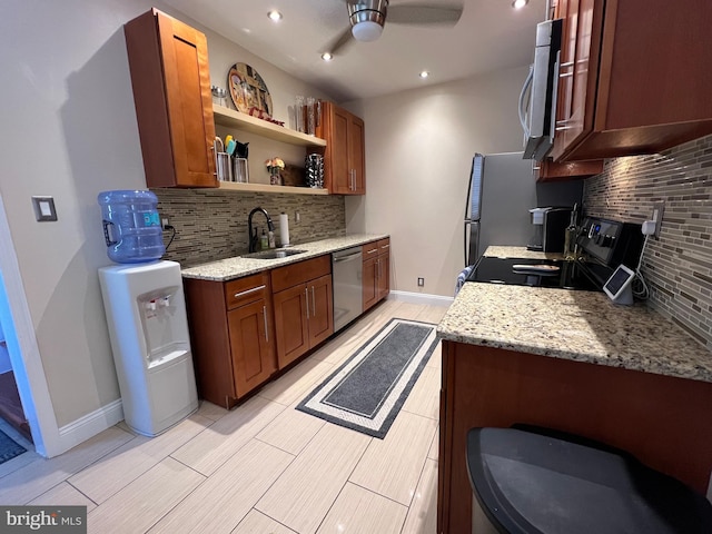 kitchen with light stone countertops, decorative backsplash, appliances with stainless steel finishes, and sink