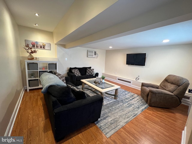 living room featuring a wall unit AC and hardwood / wood-style flooring