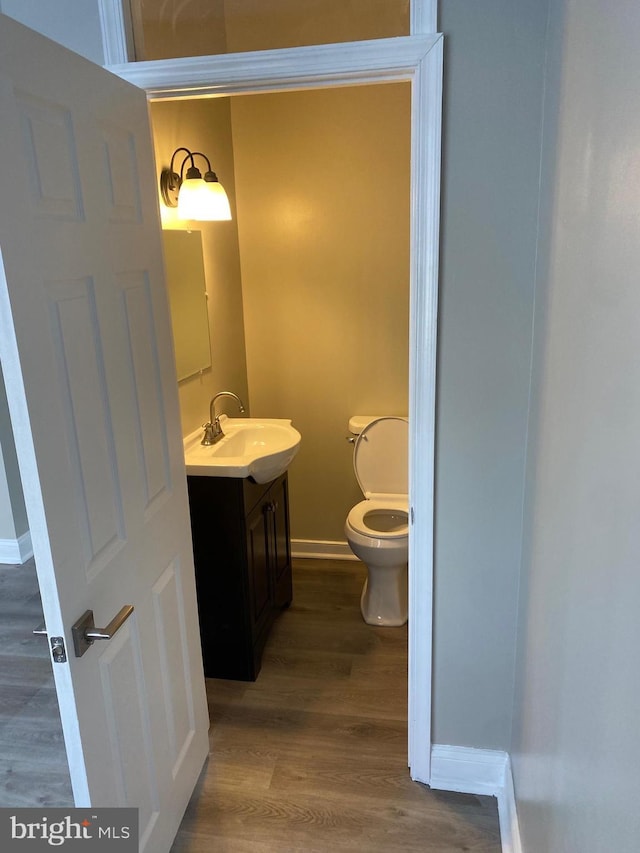 bathroom featuring toilet, wood-type flooring, and vanity