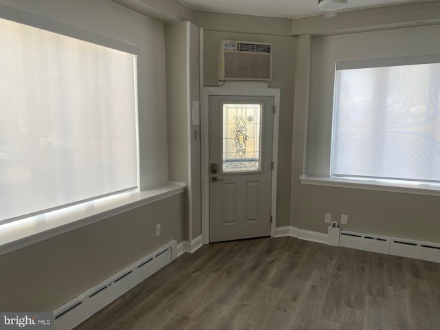 doorway featuring a baseboard heating unit, dark hardwood / wood-style flooring, and an AC wall unit