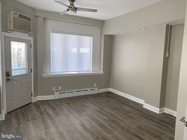 interior space featuring ceiling fan, a baseboard heating unit, dark hardwood / wood-style floors, and an AC wall unit