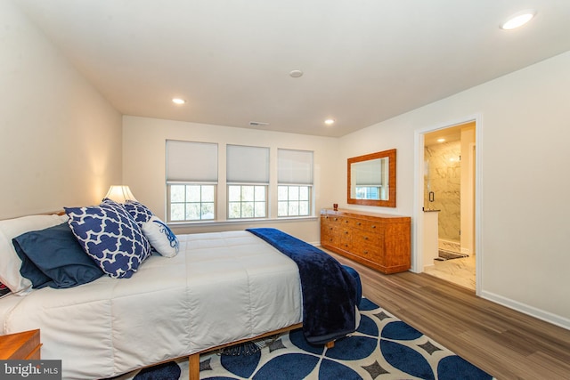 bedroom with ensuite bath and hardwood / wood-style flooring