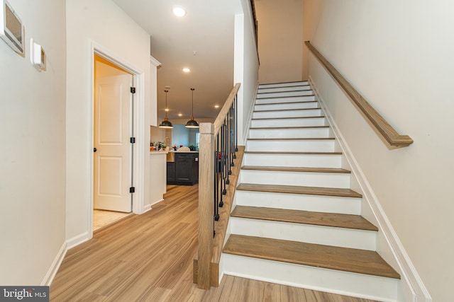 stairs featuring hardwood / wood-style floors