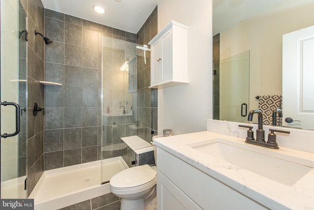 bathroom featuring toilet, a shower with door, tile patterned floors, and vanity