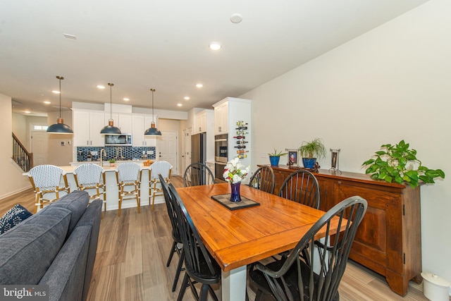 dining area with sink and light hardwood / wood-style floors