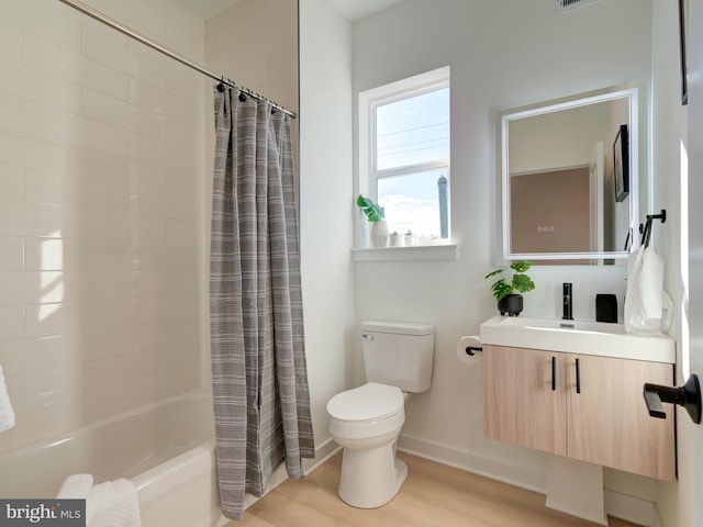 full bathroom with hardwood / wood-style floors, vanity, toilet, and shower / bath combo with shower curtain