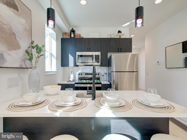 kitchen featuring a breakfast bar area, pendant lighting, and stainless steel appliances