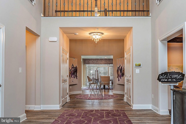 entrance foyer featuring a towering ceiling, a chandelier, and dark hardwood / wood-style floors