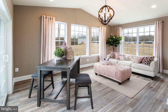 living room featuring a chandelier, lofted ceiling, and wood-type flooring