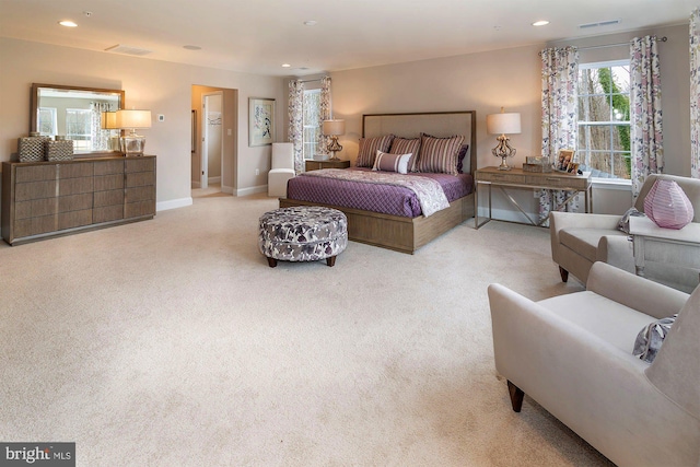 bedroom featuring light colored carpet and multiple windows