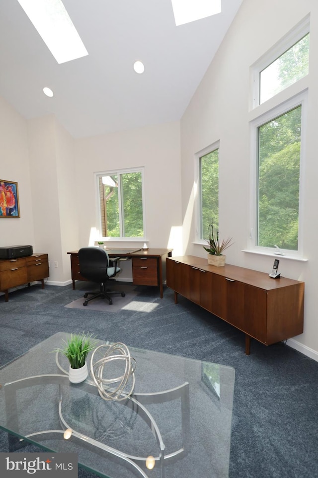 carpeted office with vaulted ceiling with skylight