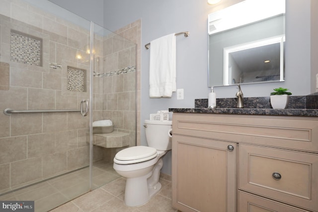 bathroom featuring tile patterned floors, walk in shower, vanity, and toilet