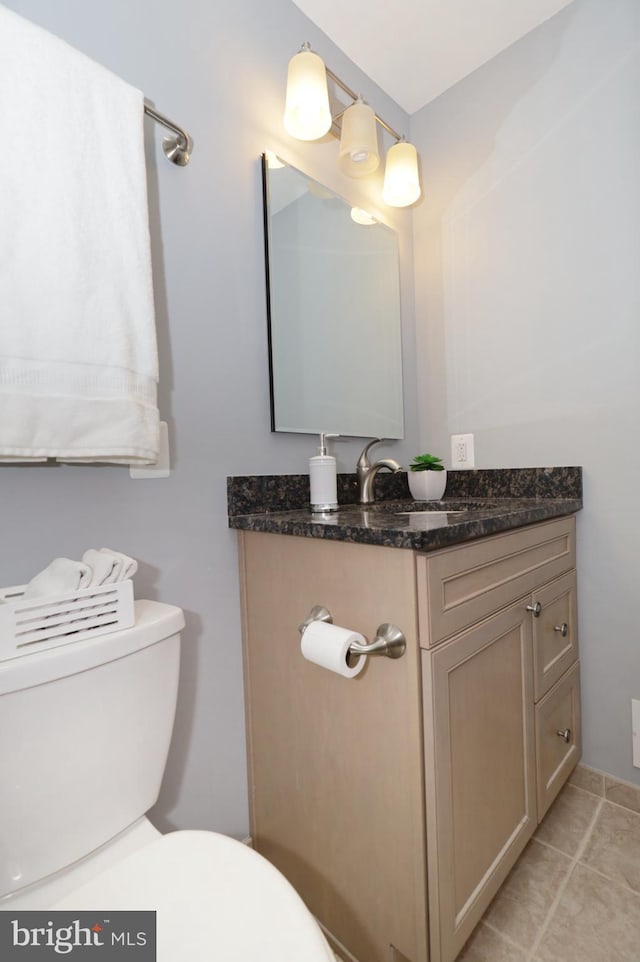 bathroom featuring tile patterned floors, vanity, and toilet