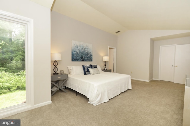 carpeted bedroom featuring lofted ceiling and multiple windows