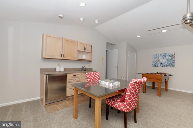 dining room featuring light colored carpet, lofted ceiling, and sink