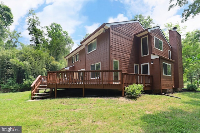 back of house featuring a lawn and a wooden deck