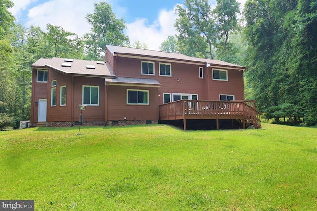 rear view of property with a deck, central AC unit, and a lawn