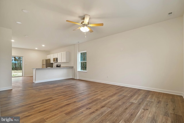 unfurnished living room with wood-type flooring and ceiling fan