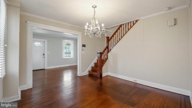 foyer entrance with ornamental molding, stairway, baseboards, and wood finished floors