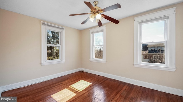 spare room with hardwood / wood-style flooring, ceiling fan, and baseboards