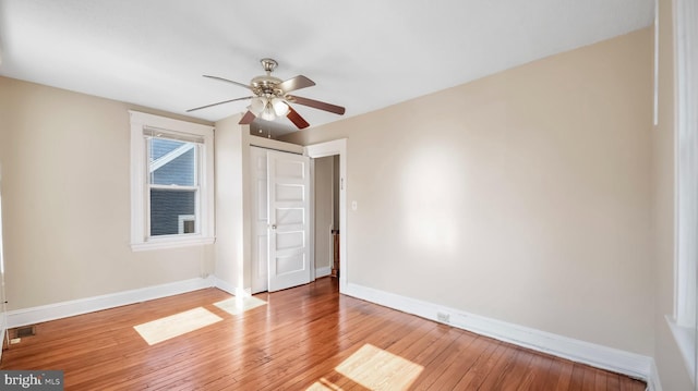 unfurnished bedroom featuring light wood-style flooring, visible vents, baseboards, and ceiling fan