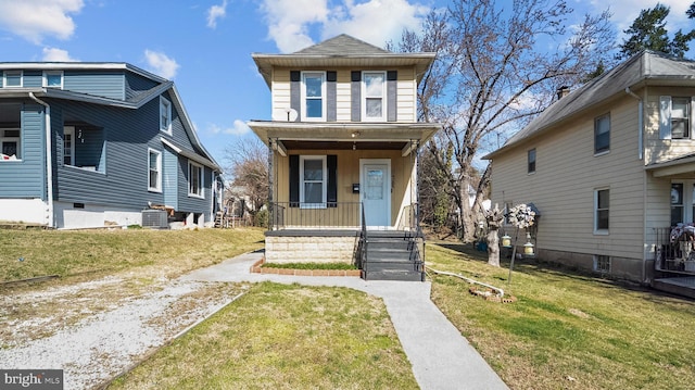 american foursquare style home with a porch, a front yard, a shingled roof, and central AC unit