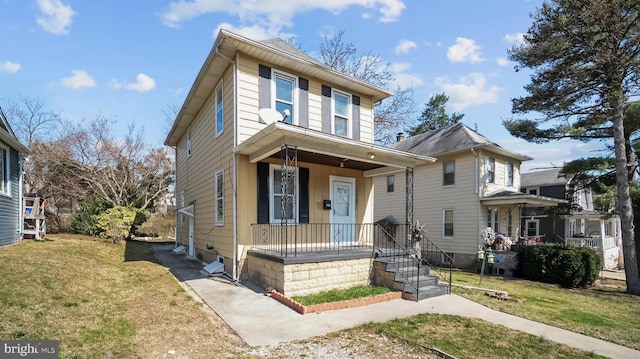 traditional style home with covered porch and a front lawn