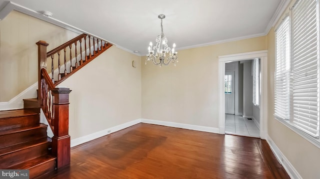 unfurnished dining area featuring hardwood / wood-style flooring, stairs, and crown molding