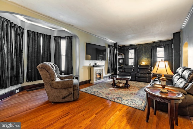 living room with a fireplace, hardwood / wood-style floors, and ornamental molding