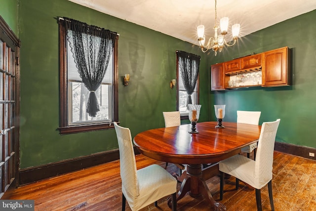 dining space with hardwood / wood-style flooring and an inviting chandelier