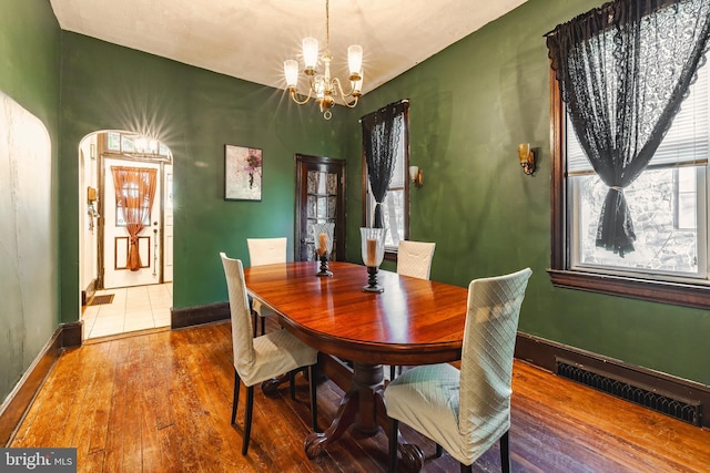 dining space featuring an inviting chandelier and hardwood / wood-style flooring