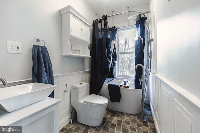 full bathroom featuring toilet, shower / bathtub combination with curtain, and sink