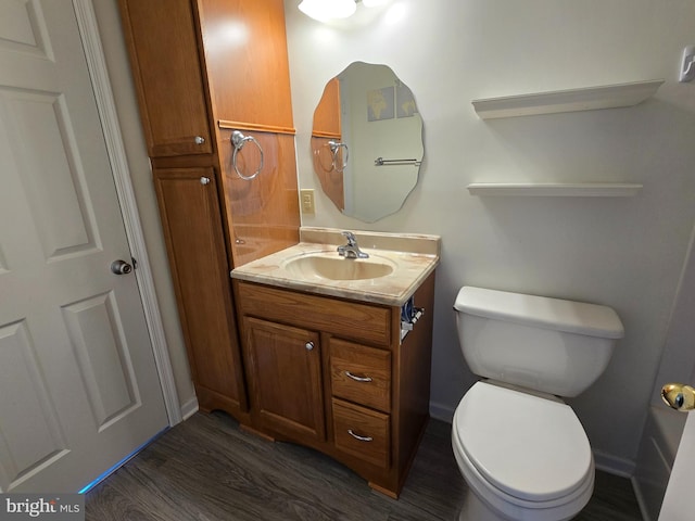 bathroom featuring toilet, wood-type flooring, and vanity