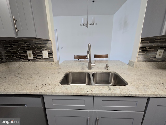 kitchen featuring sink, gray cabinetry, dishwasher, and light stone countertops